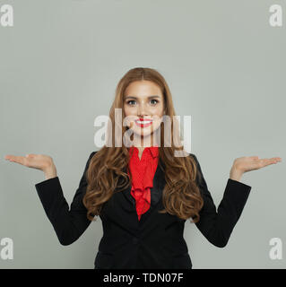 Donna di successo tenendo due vuoto mano aperta su sfondo bianco. Tasso, pesare e rappresentano Foto Stock