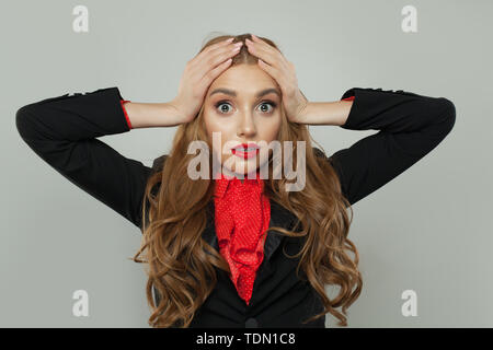 Scioccato donna che mantiene la sua testa con le mani Foto Stock