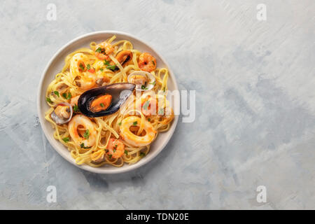 Piatti di pasta. Un overhead foto di un piatto di tagliolini con cozze, gamberi, vongole e anelli di totano, con copyspace Foto Stock