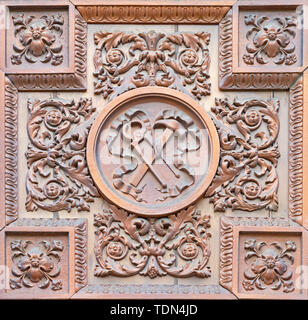 COMO, Italia - 8 Maggio 2015: il Metallo - Legno di rilievo con la instrumnest della Crocifissione sulla porta della Chiesa Santuario del Santissimo Crocifisso. Foto Stock