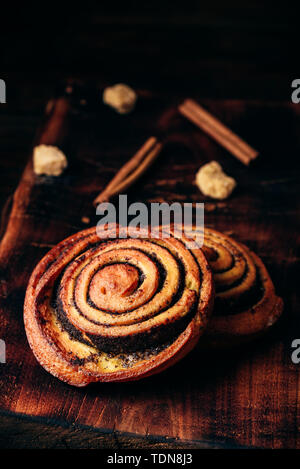 Rotolo dolce con semi di papavero rustico superficie in legno Foto Stock