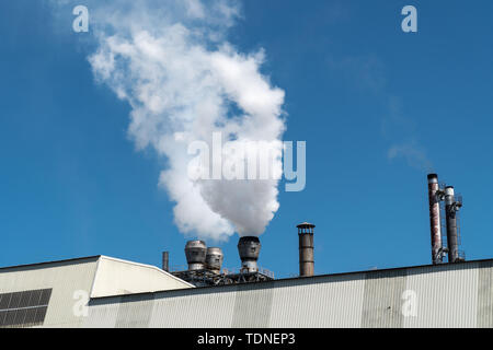 Emissione di fumo dalla fabbrica tubi sul cielo blu Foto Stock