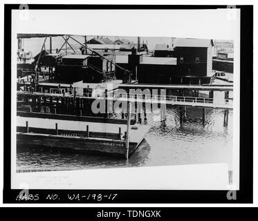 (Stampa originale, Museo Anacortes.) Fotografo sconosciuto, c. 1915. Vista verso il nord-est e ovest della banchina principale in background. Da destra a sinistra- cemento e gesso magazzino (etichettato "Curtis Wharf magazzino -2'); mulino di alimentazione; e opere di imbottigliamento, con la sabbia e ghiaia Pontile di fronte ad esso, a sinistra. - Curtis Wharf, O e seconda strade, Anacortes, Skagit County, WA; Maul, David, trasmettitore Foto Stock