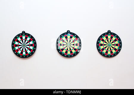 Tre Dartboard con un dardo su un muro grigio close up Foto Stock