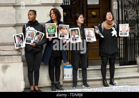 I dimostranti tenere cartelloni con foto di dirigenti sociali uccisi in Colombia durante la protesta. I manifestanti radunati fuori Gibson Hall di protesta contro il presidente colombiano Ivan Duque la visita a Londra. Essi sono contrari al colombiano di governo della destra e la mancanza di protezione sociale colombiane responsabili, che sono state sistematicamente uccisi in Colombia Negli ultimi anni. Essi chiedono protezione per i dirigenti sociali e l' attuazione dell' accordo di pace con le FARC smobilitati. Manifestanti hanno posto una lunga 50m banner sul marciapiede esterno Gibson Hall con i nomi di m Foto Stock