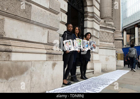 I dimostranti tenere cartelloni con le foto dei dirigenti sociali uccisi in Colombia durante la protesta. I manifestanti radunati fuori Gibson Hall di protesta contro il presidente colombiano Ivan Duque la visita a Londra. Essi sono contrari al colombiano di governo della destra e la mancanza di protezione sociale colombiane responsabili, che sono state sistematicamente uccisi in Colombia Negli ultimi anni. Essi chiedono protezione per i dirigenti sociali e l' attuazione dell' accordo di pace con le FARC smobilitati. Manifestanti hanno posto una lunga 50m banner sul marciapiede esterno Gibson Hall con i nomi Foto Stock