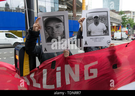 I dimostranti tenere cartelloni con le foto dei dirigenti sociali uccisi in Colombia durante la protesta. I manifestanti radunati fuori Gibson Hall di protesta contro il presidente colombiano Ivan Duque la visita a Londra. Essi sono contrari al colombiano di governo della destra e la mancanza di protezione sociale colombiane responsabili, che sono state sistematicamente uccisi in Colombia Negli ultimi anni. Essi chiedono protezione per i dirigenti sociali e l' attuazione dell' accordo di pace con le FARC smobilitati. Manifestanti hanno posto una lunga 50m banner sul marciapiede esterno Gibson Hall con i nomi Foto Stock