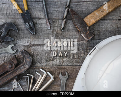 Festa del lavoro. Gli strumenti a mano e lettere in legno giacente sul tavolo. Vista superiore, close-up. Preparazione per la celebrazione. Congratulazioni ai cari, famiglia, Foto Stock