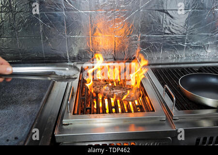 Succosa bistecca con erbe aromatiche sul grill Foto Stock