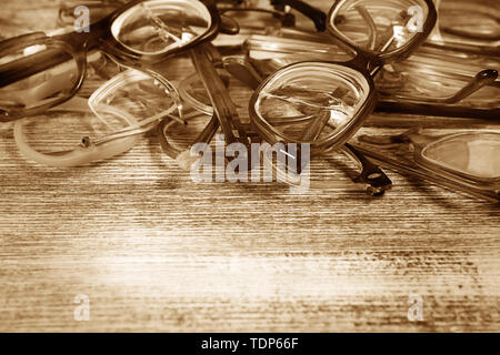 Diversi gli occhiali rotti su sfondo di legno e lo spazio di testo Foto Stock