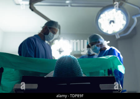 Il team medico di esaminare la donna incinta durante la consegna nel teatro di funzionamento Foto Stock