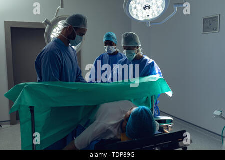 Il team medico di esaminare la donna incinta durante la consegna nel teatro di funzionamento Foto Stock
