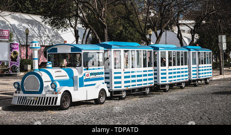 Faro, Portogallo - 1 Maggio 2018: piccolo treno turistico che circondano la città nel centro storico della città in un giorno di primavera Foto Stock