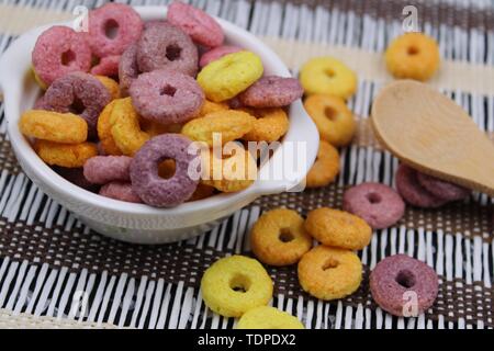 Di piccole dimensioni e di colore bianco con vaso colorato round cereali e cucchiaio di legno Foto Stock