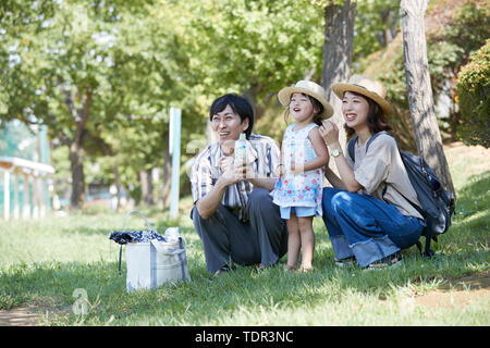 Famiglia giapponese in un parco della città Foto Stock