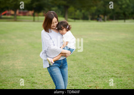 Famiglia giapponese in un parco della città Foto Stock