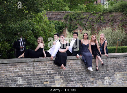 Cambridge, Cambridgeshire, Regno Unito. Il 18 giugno, 2019. Gli studenti universitari a sedersi su una parete accanto al fiume Cam nelle prime ore del mattino dopo per celebrare la fine dei loro esami e frequentando la Trinità può palla, Cambridge, Cambridgeshire, il 18 giugno 2019. Credito: Paolo Marriott/Alamy Live News Foto Stock