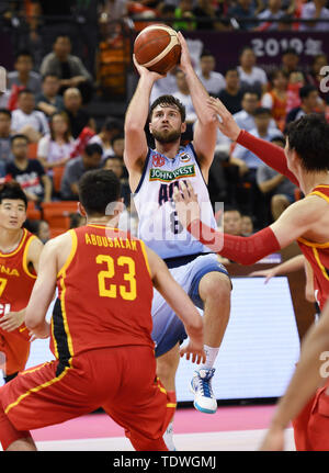 Qingdao, Cina Shandong. 19 giugno 2019. Mitch Norton (L) di Australian NBL spara la sfera durante l'Sino-Australian di pallacanestro degli uomini di sfida tra Cina e Australia NBL team a Qingdao, Cina orientale della provincia di Shandong, 19 giugno 2019. Credito: Li Ziheng/Xinhua/Alamy Live News Foto Stock