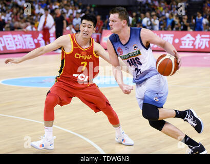 Qingdao, Cina Shandong. 19 giugno 2019. Daniel Johnson (R) di Australian NBL rompe attraverso durante il Sino-Australian di pallacanestro degli uomini di sfida tra Cina e Australia NBL team a Qingdao, Cina orientale della provincia di Shandong, 19 giugno 2019. Credito: Li Ziheng/Xinhua/Alamy Live News Foto Stock