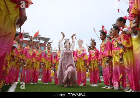 Gansu Gansu, Cina. Xx Giugno, 2019. Gansu, Cina - 20 Giugno 2019: l'erede del patrimonio culturale immateriale è istruire i bambini per eseguire il non-l'eredità genetica programma a proposito della pagoda di ciotola danza nel parco giochi di minle imbarco scuola primaria di minle county, zhangye città, provincia di Gansu.Minleding pagoda di ciotola di danza folk combina le acrobazie con la danza, che riflette una sorta di danza composta, eseguita e goduto dagli antichi soldati e civili, usando tazze di riso come puntelli e materiali locali nel loro lavoro. Credito: ZUMA Press, Inc./Alamy Live News Foto Stock