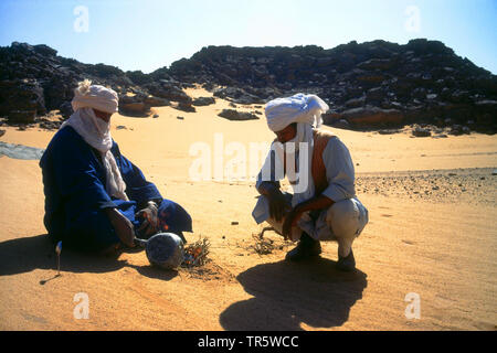 Due impostazione Tuaregs incendio nel Sahara, Libia Foto Stock