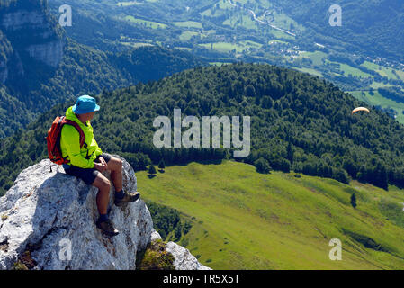 Wanderer seduto sulla vetta del Col de la sicuri e godendo della vista, Francia, Isere, Chartreuse, Grenoble Foto Stock