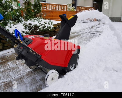 Uomo con snowblow rimozione neve da un marciapiede, in Germania, in Renania settentrionale-Vestfalia, la zona della Ruhr, Witten Foto Stock