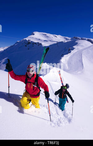 Gli sciatori a piedi attraverso polvere di neve sulla strada per la cima della montagna, Francia, Savoie, Sainte Foy Tarentaise Foto Stock