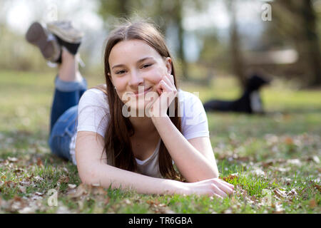 Giovane donna sdraiata su un prato, Germania Foto Stock