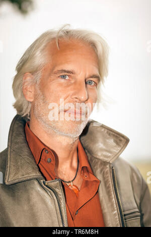 Uomo anziano con il grigio capelli lunghi e giacca di pelle, Germania Foto Stock