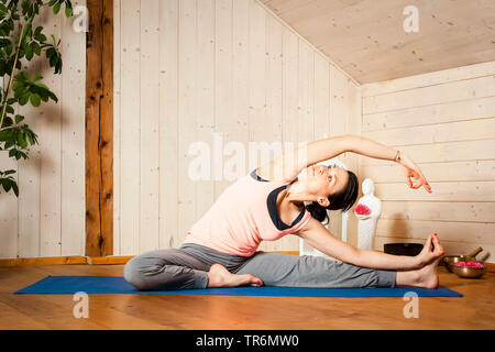 La donna a praticare yoga su un materassino yoga nel piatto, Germania Foto Stock