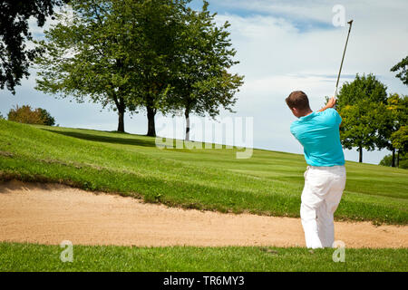 Giovane uomo giocando a golf, Germania Foto Stock