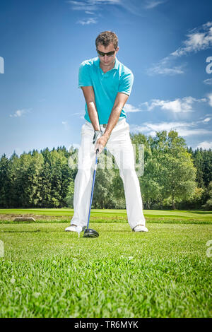 Giovane uomo giocando a golf, Germania Foto Stock