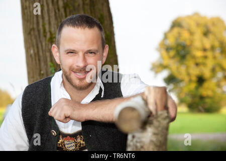 Tradizionale bavarese vestito uomo seduto su una panchina, in Germania, in Baviera Foto Stock