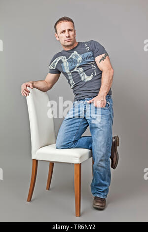 Ritratto di un uomo anziano con t-shirt e jeans, posa, Germania Foto Stock