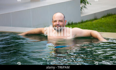 L'uomo rilassante in piscina, Germania Foto Stock