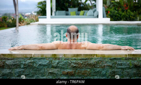 L'uomo rilassante in piscina, Germania Foto Stock