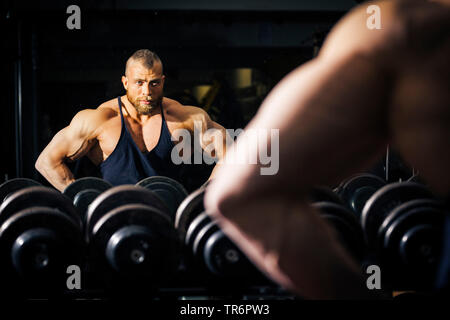 Allestitore di formazione in un centro fitness di fronte a uno specchio, Germania Foto Stock