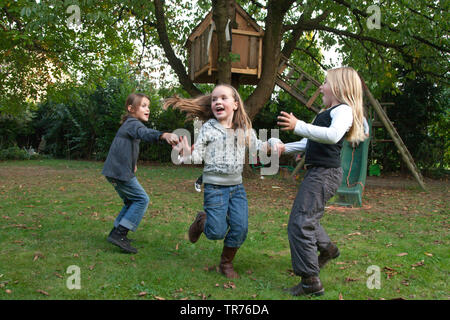 Tre bambini che giocano frolicsome vicino a un albero di casa, Paesi Bassi Limburg Foto Stock