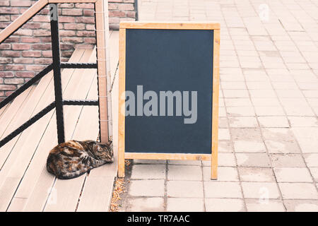 Menu vuoto stand e cat on cafe esterno sfondo, mock up Foto Stock