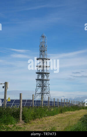 Telefono Mobile communications torre accanto a una fattoria solare Foto Stock