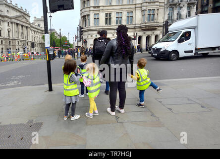 Londra, Inghilterra, Regno Unito. Gruppo dei bambini in attesa di attraversare la strada Foto Stock