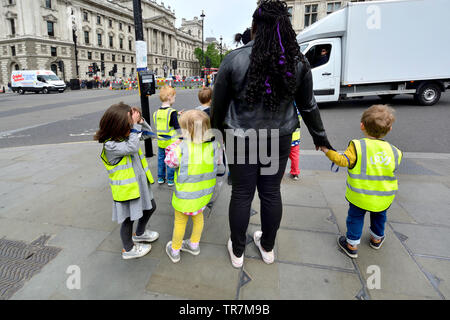 Londra, Inghilterra, Regno Unito. Gruppo dei bambini in attesa di attraversare la strada Foto Stock