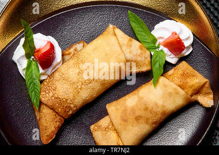 Pancake con fragole e panna. Foto Stock