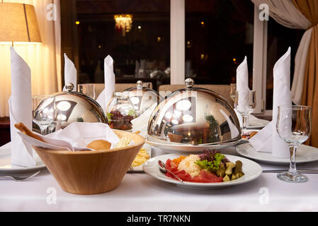 Servita la cena table.piatto caldo sulla cupola il vassoio sulla tavola server. Foto Stock