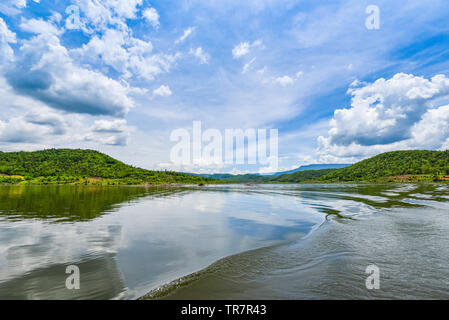 Paesaggio e vista sul fiume dalla barca da pesca wave stern sul luminoso giorno bella natura / lago verde con il cloud cielo blu e lo sfondo di montagna Foto Stock