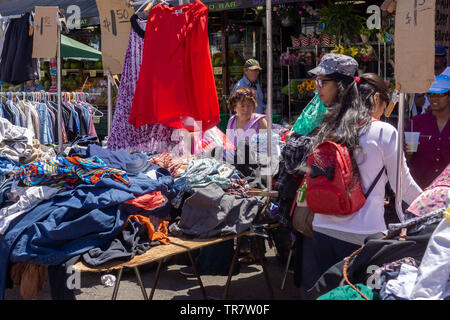Shoppers sfoglia a buon mercato Cinese fabbricati capi di vestiario a una fiera di strada nel quartiere di Astoria di New York lunedì, 27 maggio 2019. (© Richard B. Levine) Foto Stock