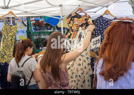 Shoppers sfoglia a buon mercato Cinese fabbricati capi di vestiario a una fiera di strada nel quartiere di Astoria di New York lunedì, 27 maggio 2019. (© Richard B. Levine) Foto Stock