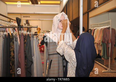 Una donna che indossa un velo o hijab ad una femmina di manichino in Indonesia musulmana Expo di moda. Musulmani industria moda cresce molto rapidamente in Indonesia nel Foto Stock