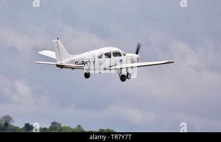 La Bader bus del display Azienda Team - Piper PA-28 Warrior (G-BSYY) prendendo il largo al 2019 Duxford Air Festival Foto Stock